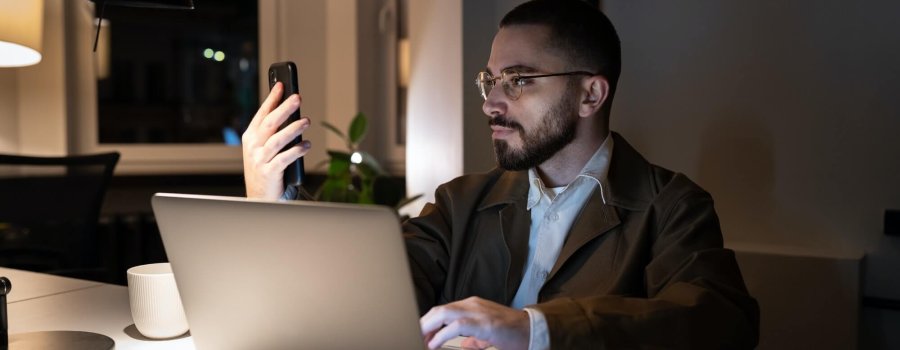 Busy front end developer or qa engineer testing app on smartphone work overtime in coworking space