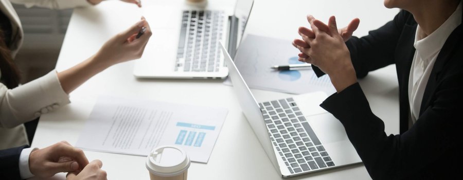 Smiling businesswoman enjoying talk with colleagues during teamwork with laptops